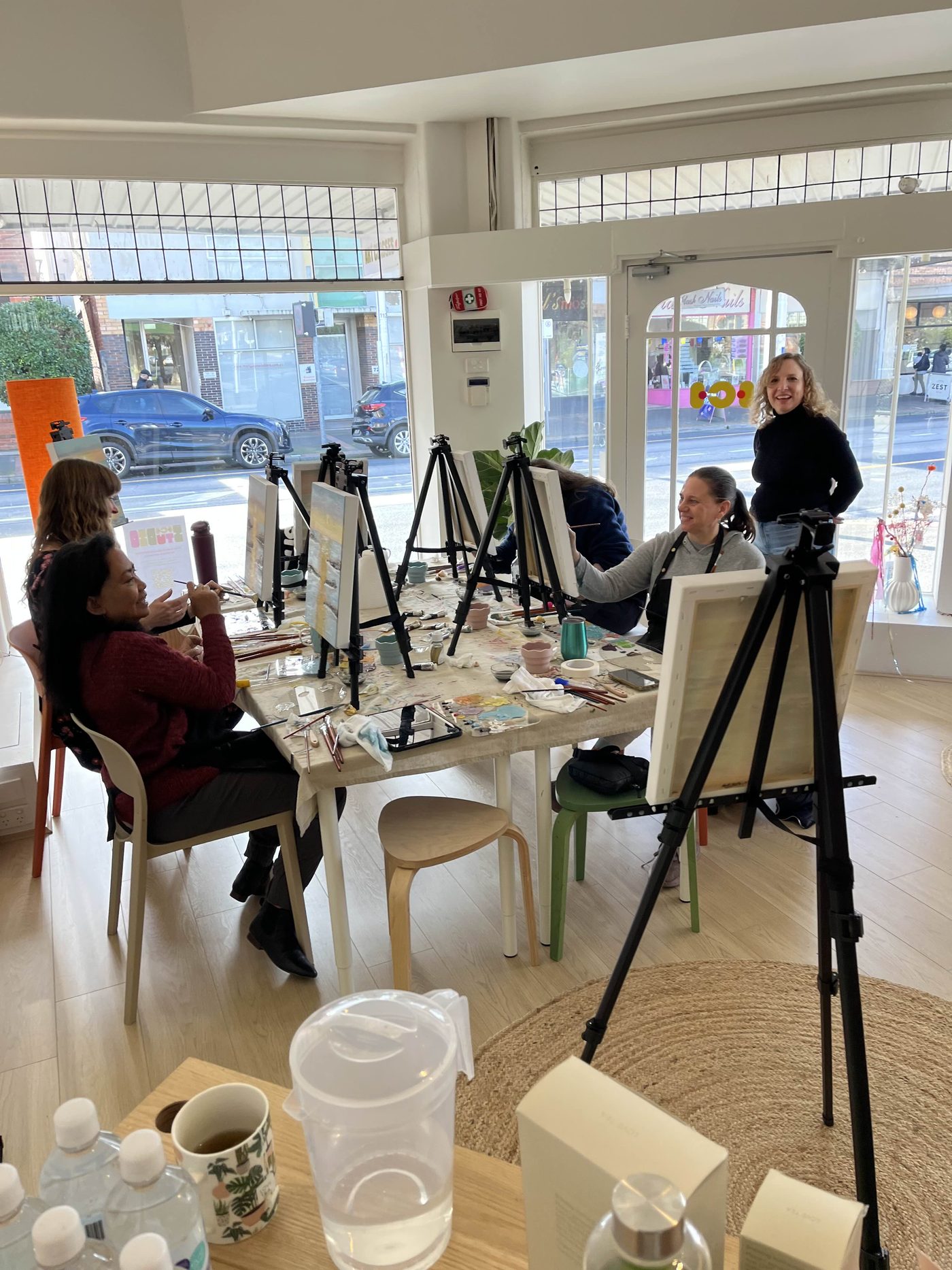 Students painting at easels during a small-group class